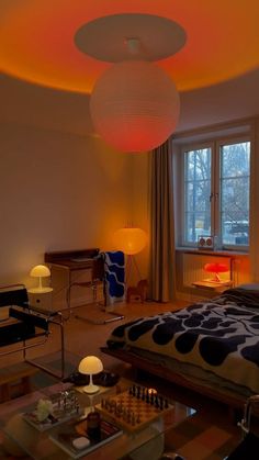 a bed room with a neatly made bed next to a table and two lamps on either side of the bed