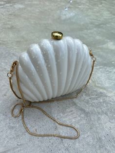 Embrace seaside charm with the Seashell Purse in Pearl White. The seashell shaped exterior featuring gold hardware is the perfect accessory to turn heads. The fabric lined material and detachable chain ensures functionality. Elegant White Shell For Vacation, Elegant Shell For Summer Vacation, Elegant Summer Shell For Vacation, Towel Aesthetic, Seashell Purse, Shell Purse, Animal Prints Pattern, White Towels, Sales Gifts