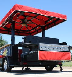 a food truck with an awning over it's top and grill on the back