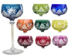 many different colored glass goblets sitting next to each other on a white background