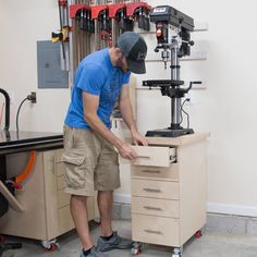 a man working on a workbench with a driller and visor in his hand