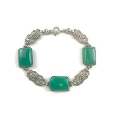 German Chrysoprase Sterling Silver bracelet from the Art Deco era. Hallmarks: The bracelet is marked Germany on the clasp and Sterling on the back of one of the Chrysoprase links. Age: circa 1920s Measurements: The bracelet weighs 12 grams and is 7 1/4 inches long. The three green gemstones measure about 5/8 inch by 1/2 inch each. Elegant Green Cabochon Bracelets, Green Cabochon Bracelets As A Gift, Green Cabochon Bracelets For Gift, Green Cabochon Bracelet For Formal Occasions, Formal Silver Jade Bracelets, Green Cabochon Bracelets For Formal Occasions, Formal Green Cabochon Bracelets, Formal Green Cabochon Bracelet, Handmade Elegant Green Sterling Silver Bracelet