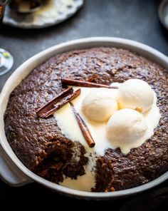 a chocolate cake with ice cream and pecans on top, sitting in a pan