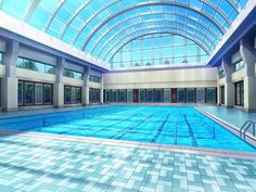 an indoor swimming pool with tiled floors and skylights