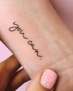 a woman's foot with the word love tattooed on her left leg and pink nail polish