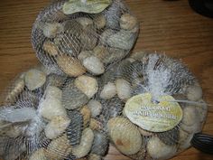 two mesh bags filled with nuts sitting on top of a wooden table