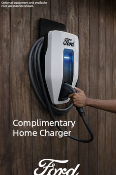 a person is plugging in to a wall charger with the words complimentary home charger