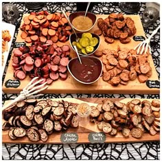 an assortment of meats and vegetables on display at a buffet table with utensils