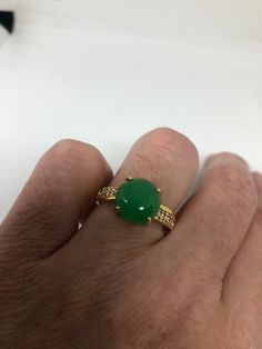 Vintage Lucky Green Nephrite Jade ring Fun jade is color enhanced Large green nephrite jade Ornate German Silver with golden finish Vintage ring, does not tarnish, NOT sterling Size 7 or 8. All rings are shipped free in the US in a nice gift box. Check out our over a THOUSAND great reviews Engraving is $4 per letter and is not always perfect depending on the piece. It can take a few days if the jeweler is busy. This is payable to Paypal Judithsltd@gmail.com Gold Jade Emerald Ring, Yellow Gold Jade Ring With Gemstone, Green Jade Round Stone Jewelry, Green Jade Jewelry With Round Stone, Green Crystal Gemstone Ring, Green Gemstone Crystal Ring, Fine Jewelry Gold Jade Rings, Jade Gemstone Ring With Round Stone, Gold Jade Rings In Fine Jewelry Style