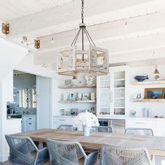 a dining room table with chairs and a chandelier hanging from it's ceiling