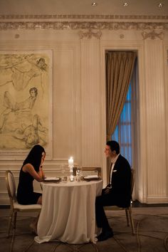 a man and woman sitting at a dinner table