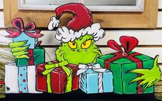 an image of a grin face with presents in front of a door way sign that says merry christmas