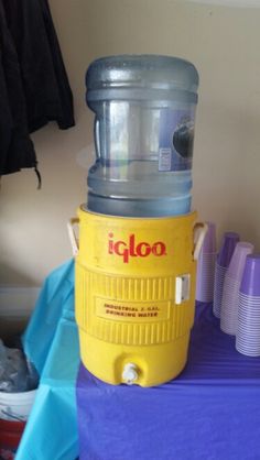 a yellow cooler sitting on top of a purple table