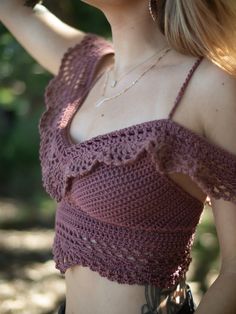 a close up of a woman wearing a top with crochet on the shoulders