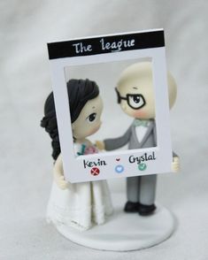 a wedding cake topper with a couple holding hands in front of a photo frame