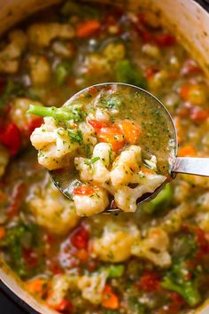 a spoon full of soup with shrimp and vegetables