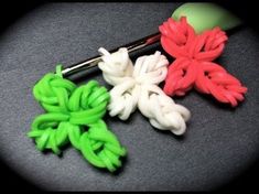 three crochet flowers sitting on top of a table next to a pair of scissors