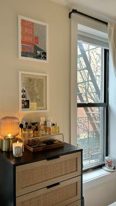 a bedroom with a dresser, window and pictures on the wall next to each other