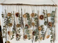 a wall hanging with dried oranges and greenery