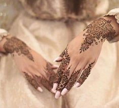 a woman's hands with henna tattoos on them