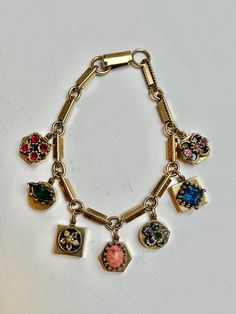 Vintage gold tone metal charm bracelet, Seven charms dangle off of the bracelet. Measures 6.5 inches, snap closure, unsigned. Excellent condition, a fun variation of a slide style charm bracelet. Cheap Trendy Bangle Charm Bracelet, Luxury Antique Gold Charm Bracelet, Luxury Heirloom Bracelet With Vintage Charm, Luxury Gold Antique-style Charm Bracelet, Cheap Gold Bracelets With Vintage Charm, Luxury Vintage Engraved Charm Bracelet, Luxury Vintage Metal Charm Bracelet, Vintage Gold Charm Bracelet With Dangling Charms, Vintage Gold Bracelet With Logo Charm