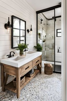 a bathroom with two sinks and mirrors on the wall, along with a tiled floor