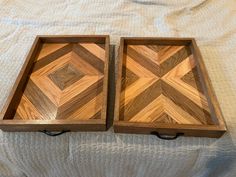 two wooden trays sitting on top of a bed