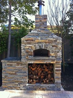 an outdoor brick oven with logs in it