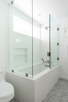 a white bathroom with a glass shower door