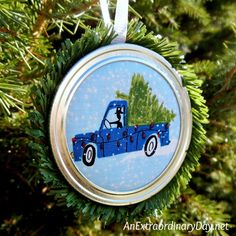 a blue truck ornament hanging from a christmas tree