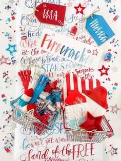 a shopping cart filled with patriotic items on top of a white paper covered in red, white and blue lettering