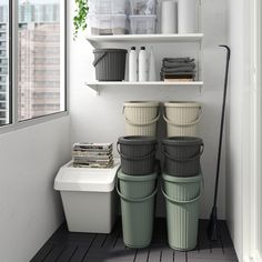 three buckets are stacked on top of each other in the corner of a room