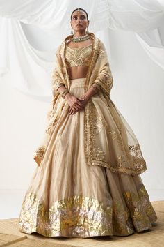 Beige attached cancan lehenga with zigzag lampi work. Comes with lampi gota sleeveless padded blouse and an organza gota patti embroidered dupatta.
Components: 3
Pattern: Embroidered
Type Of Work: Gota
Neckline: U-Neck
Sleeve Type: Sleeveless
Fabric: Lampi
Color: Beige
Other Details: 
Padded blouse
Attached cancan lehenga
Kiran lace dupatta
Approx. product weight (in kgs): 6
Length:
Blouse: 13 inches
Lehenga: 44 inches
Occasion: Wedding - Aza Fashions Gota Patti Lehenga, Orang India, Bridal Suits, Blouse Lehenga, Gold Lehenga, Black Kurta, Raw Silk Lehenga, Anamika Khanna, Diana Penty