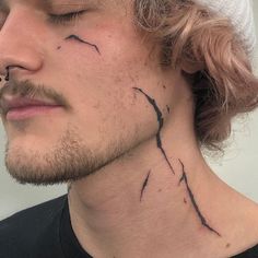 a man with a cross tattoo on his neck