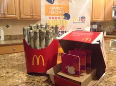 an open mcdonald's box sitting on top of a counter next to some money