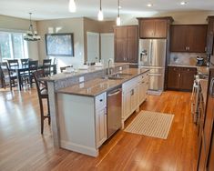 a large kitchen with wooden floors and stainless steel appliances