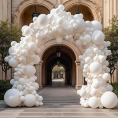 an archway with white balloons hanging from it's sides