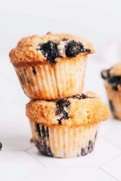 three blueberry muffins stacked on top of each other with one muffin cut in half