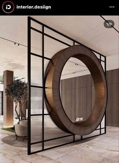 a large circular mirror sitting on the side of a wall next to a potted plant