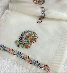 two pieces of white cloth with embroidered designs on them