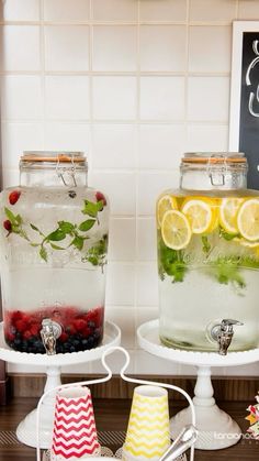 two jars filled with lemons, raspberries and water