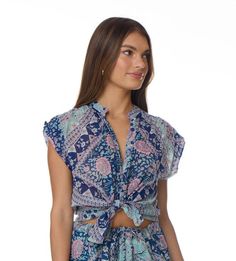 The Ginger Printed Blouse is a versatile and stylish addition to any wardrobe. Its mesmerizing floral print adds a touch of elegance to any outfit, making it the perfect choice for any occasion. This short-sleeved blouse is designed to be a universal fit, ensuring that it looks great on anyone. It is available in two beautiful colors, blue and pink, allowing you to choose the one that best suits your personal style. Made from 100% Indian cotton, this blouse is not only fashionable but also comfo Feminine Printed Short Sleeve Tops, Summer Rayon Blouse With Floral Print, Printed Short Sleeve Tops For Day Out, Floral Print Short Sleeve Tops For Day Out, Feminine Floral Print Short Sleeve Top, Feminine Short Sleeve Floral Print Top, Feminine Short Sleeve Tops For Beach, Feminine Short Sleeve Beach Tops, Printed Short Sleeve Blouse For Vacation