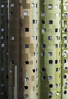 an array of green and brown buildings with holes in the sidewalls that look like they are made out of cardboard