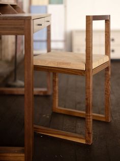 a wooden chair sitting on top of a hard wood floor next to a desk with drawers