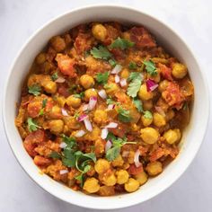 a white bowl filled with chickpeas and garnished with cilantro