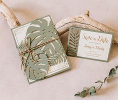 the wedding stationery is laid out next to some driftwood