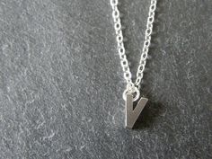 A tiny matt rhodium plated initial letter 'V' pendant dangles from a fine silver plated chain necklace.  Simple and modern. Initial 'V' pendant is matt rhodium plated, double sided, tarnish resistant, size - 5 x 7mm Fine link chain necklace is silver plated, various sizes available, please select the length you require above. Other alphabet letters available - A-Z in gold and silver: Gold personalized initial necklace, choose your own initial:- https://www.etsy.com/listing/129735775/tiny-initial-letter-matt-gold-necklace?ref=shop_home_active Silver personalized initial necklace, choose your own initial:- https://www.etsy.com/listing/129735289/tiny-silver-initial-letter-necklace?ref=shop_home_active ★ All items arrive in a gift box with ribbon.  Ready to ship.  Personalized messages and dir Letter V Necklace, Initial V, Silver Initial Necklace, V Necklace, Letter V, Necklace Simple, Alphabet Letters, Initial Letter, Personalized Initials