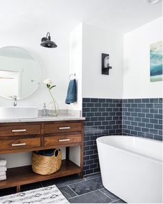 a bath room with a tub a sink and a mirror on the wall in it