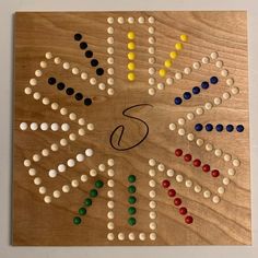 a wooden board with multiple colored dots and the word's spelled out in it