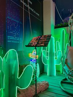 a green room with neon lights and cactus decorations on the walls, along with an easel